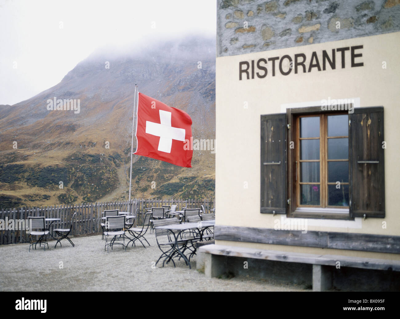 alp Grum Bernina Pass cloudiness flag Graubunden Grisons Switzerland Europe empty restaurant terrace Stock Photo