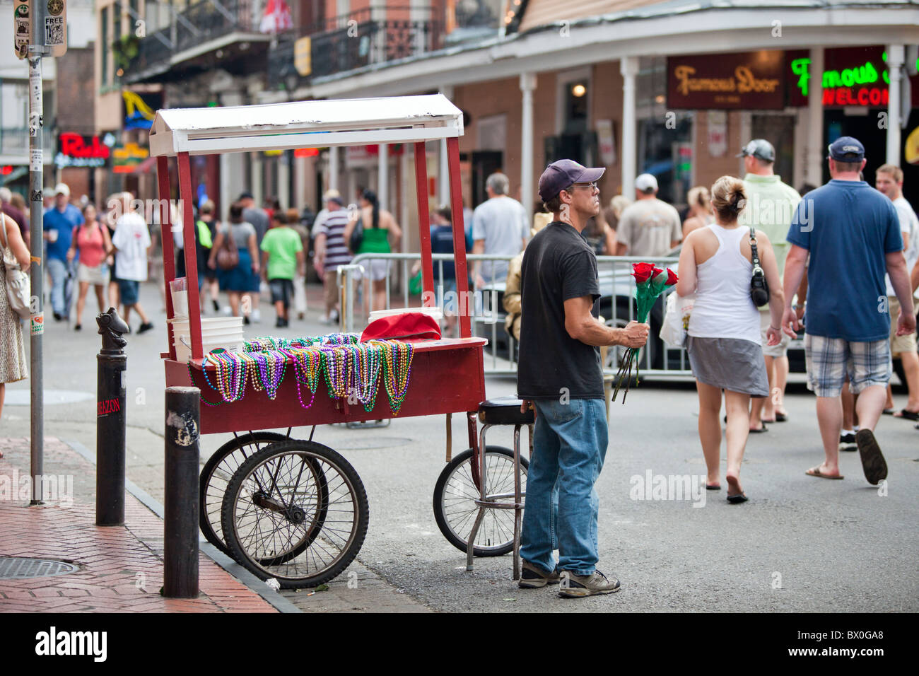 A man sells Mardi Gras beads on Bourbon Street in New Orleans, Louisiana's French Quarter Stock