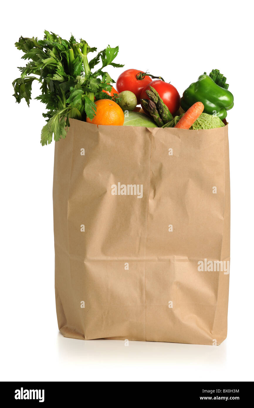 Assorted fruits and vegetables in brown grocery bag isolated over white background Stock Photo