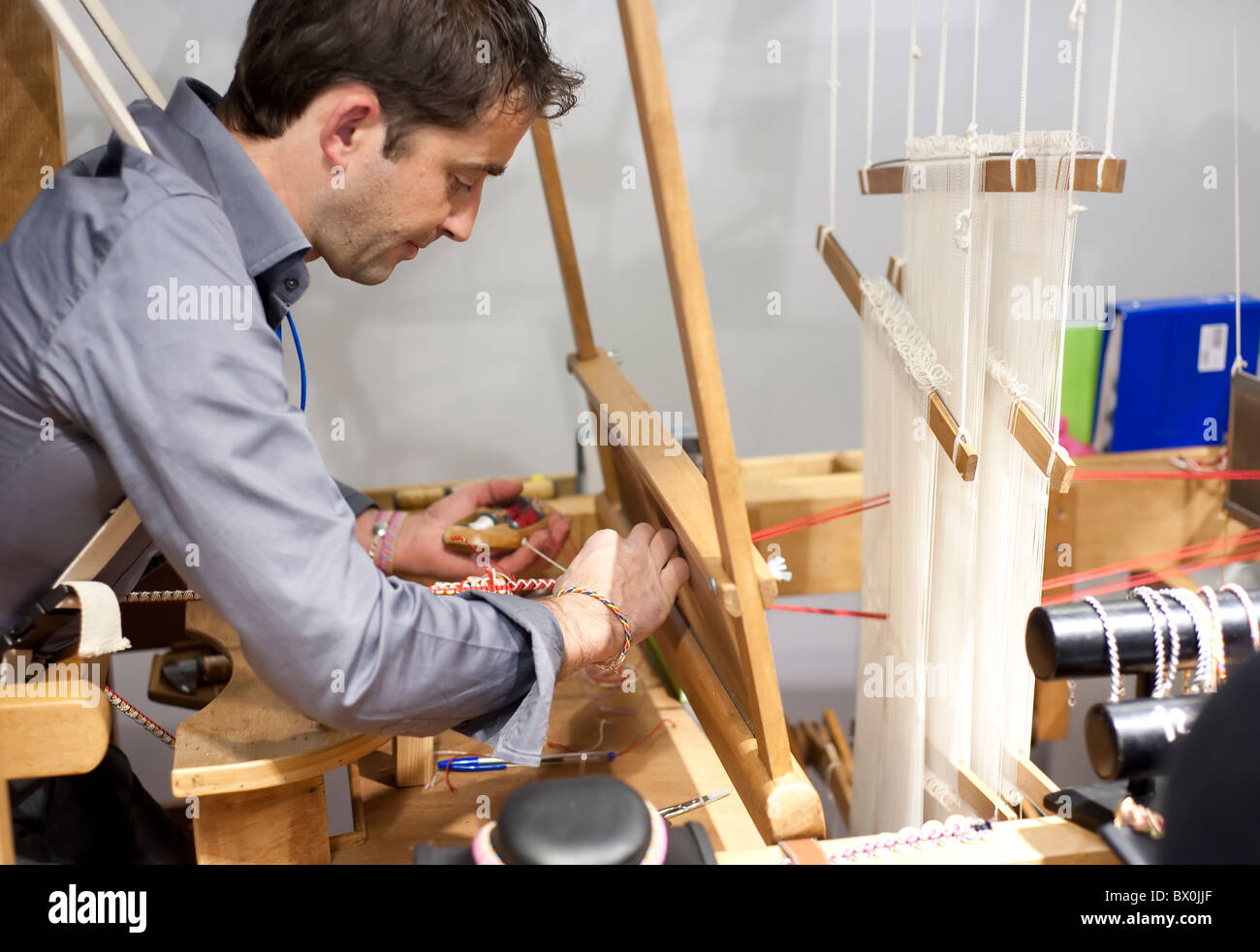 Artisan working using a loom to make bracelets Stock Photo