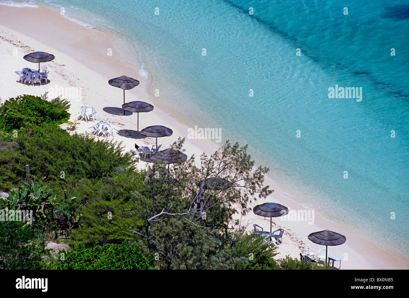 Sun umbrellas dotted along the white sand beach on Amedee Island, New Caledonia, Pacific Ocean Islands. Stock Photo