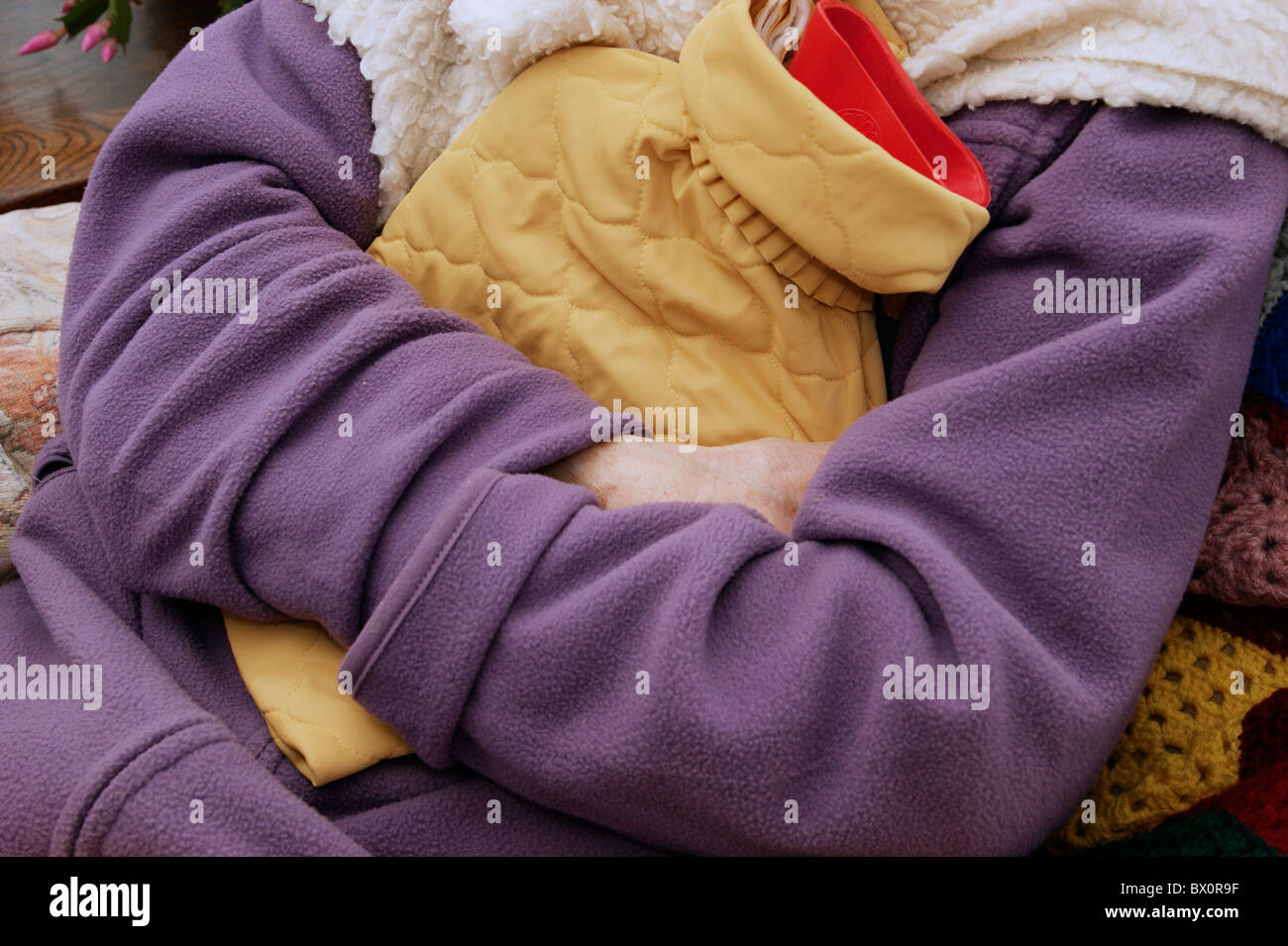 elderly woman keeping warm in winter wrapped up with a fleece blanket