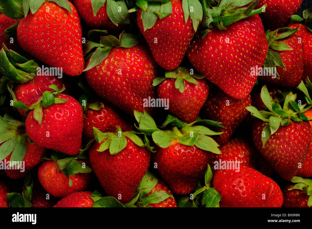 Strawberries with leaves filling the frame Stock Photo