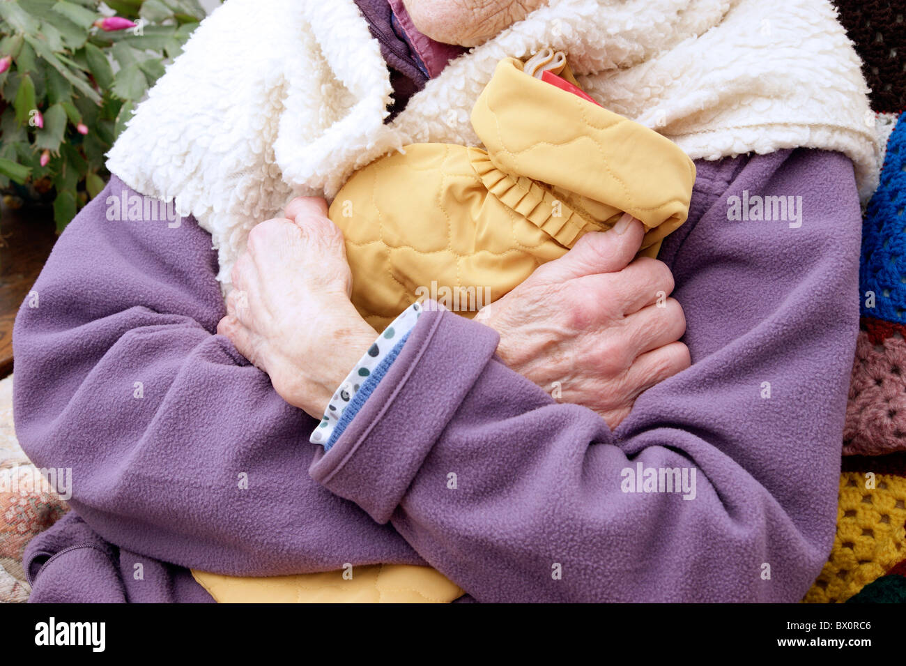 elderly woman keeping warm in winter wrapped up with a fleece blanket
