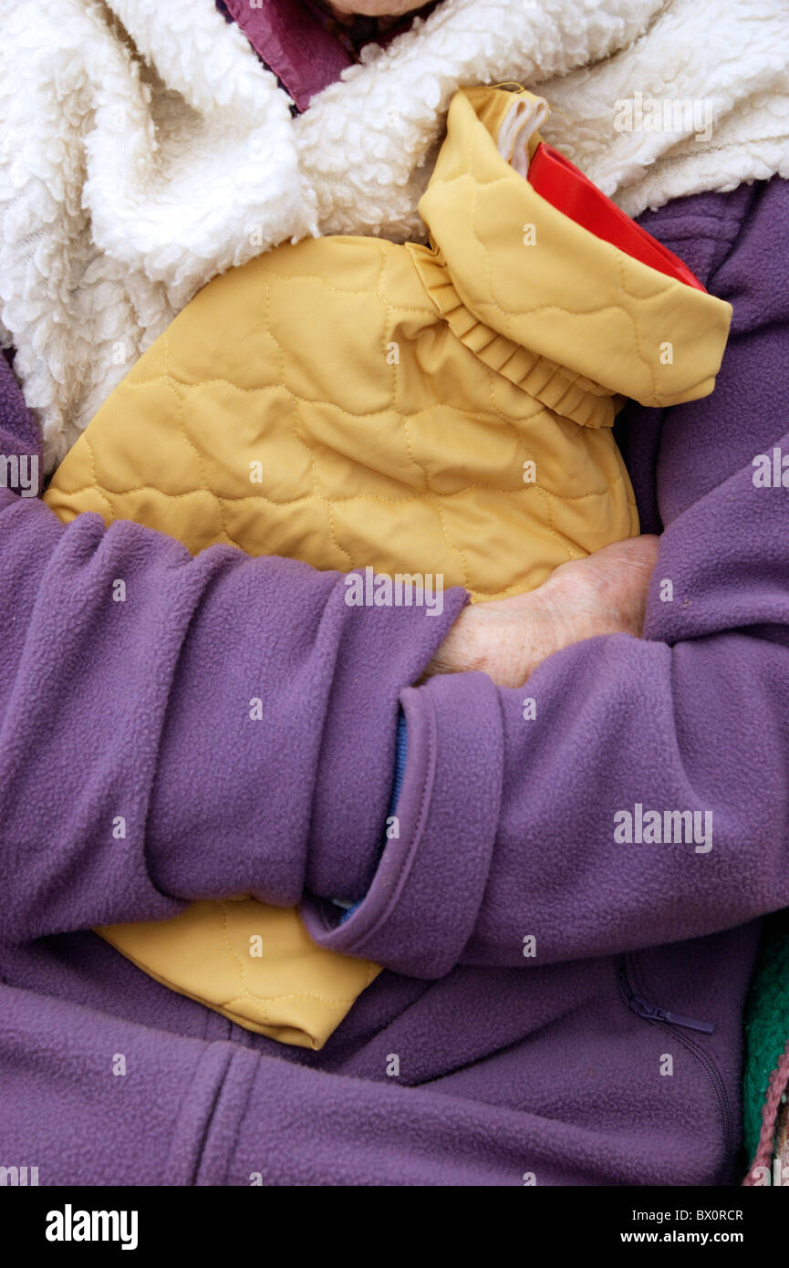 elderly woman keeping warm in winter wrapped up with a fleece blanket