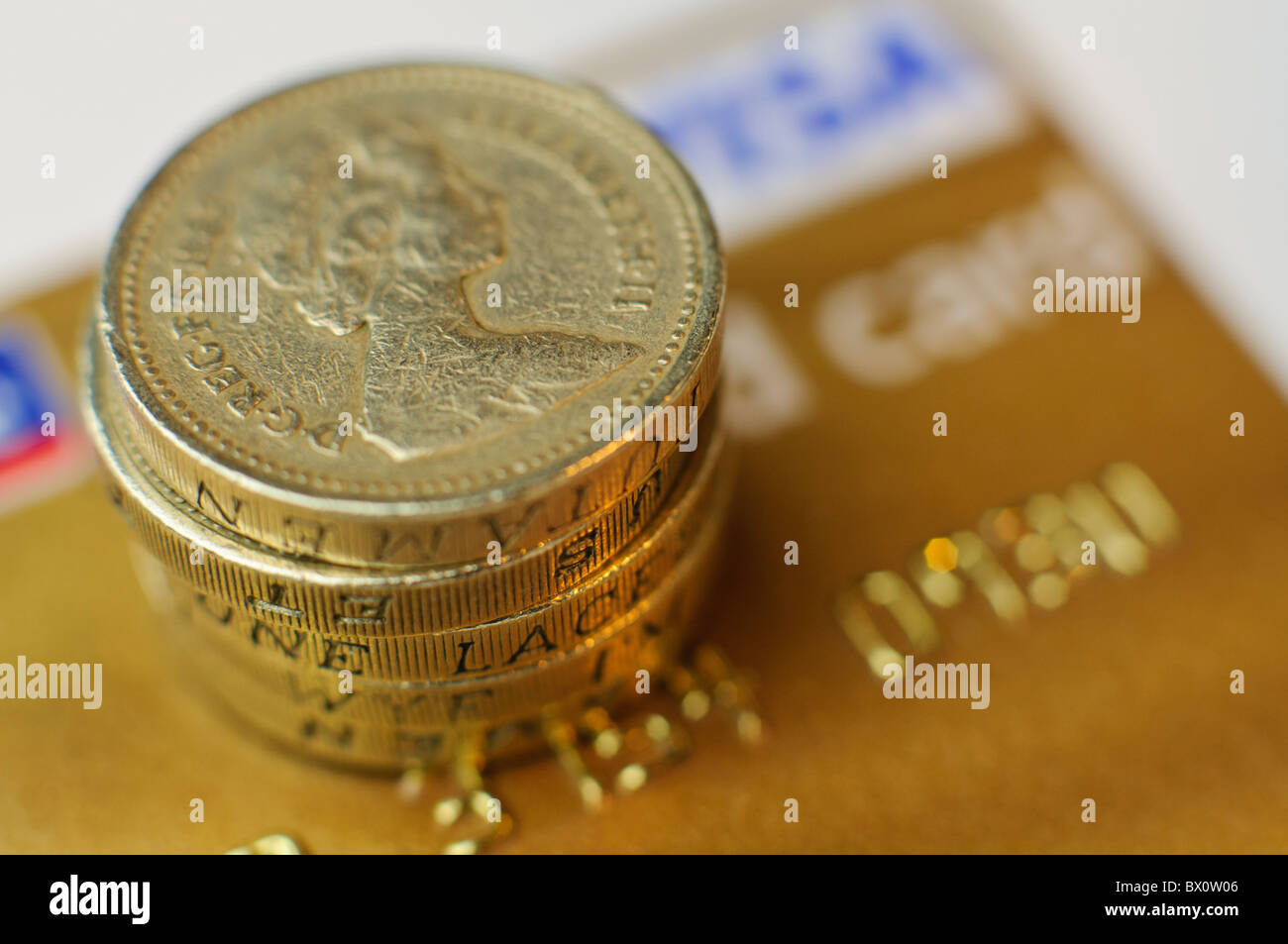 Pound coins on top of a Visa Gold Card credit card Stock Photo