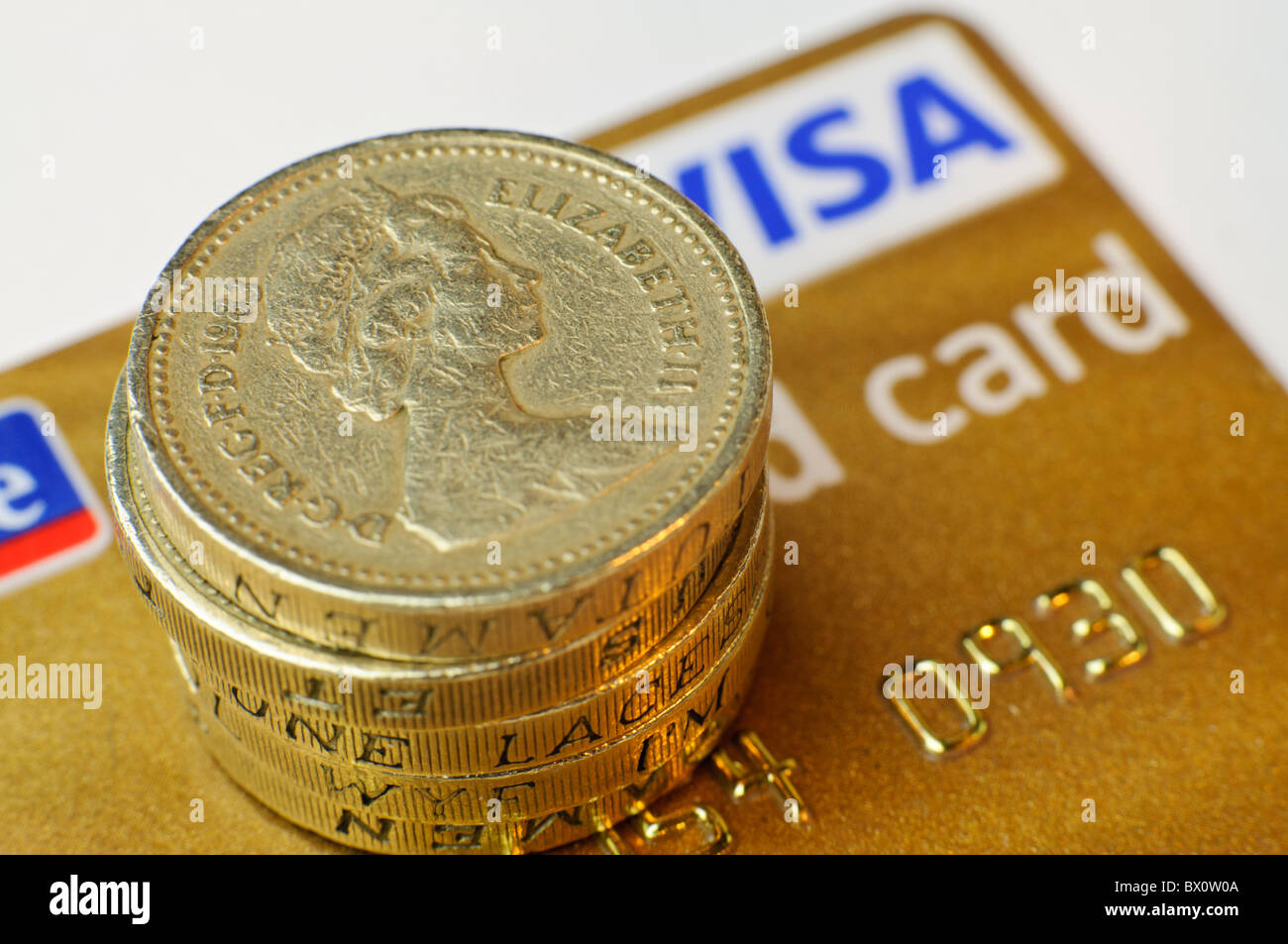 Pound coins on top of a Visa Gold Card credit card Stock Photo