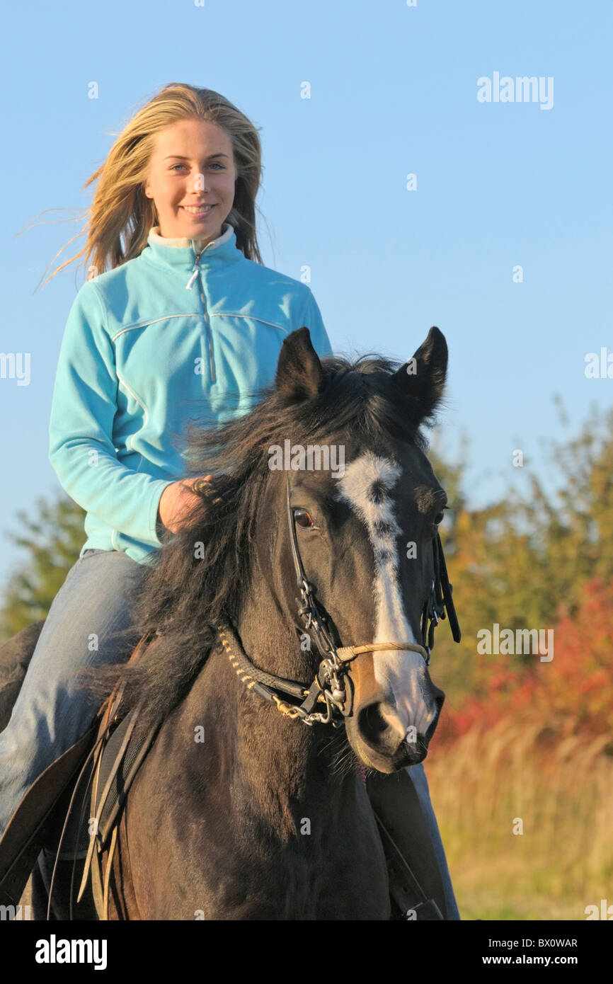 Girl during a ride out on back of a Paso Fino horse in the evening Stock Photo