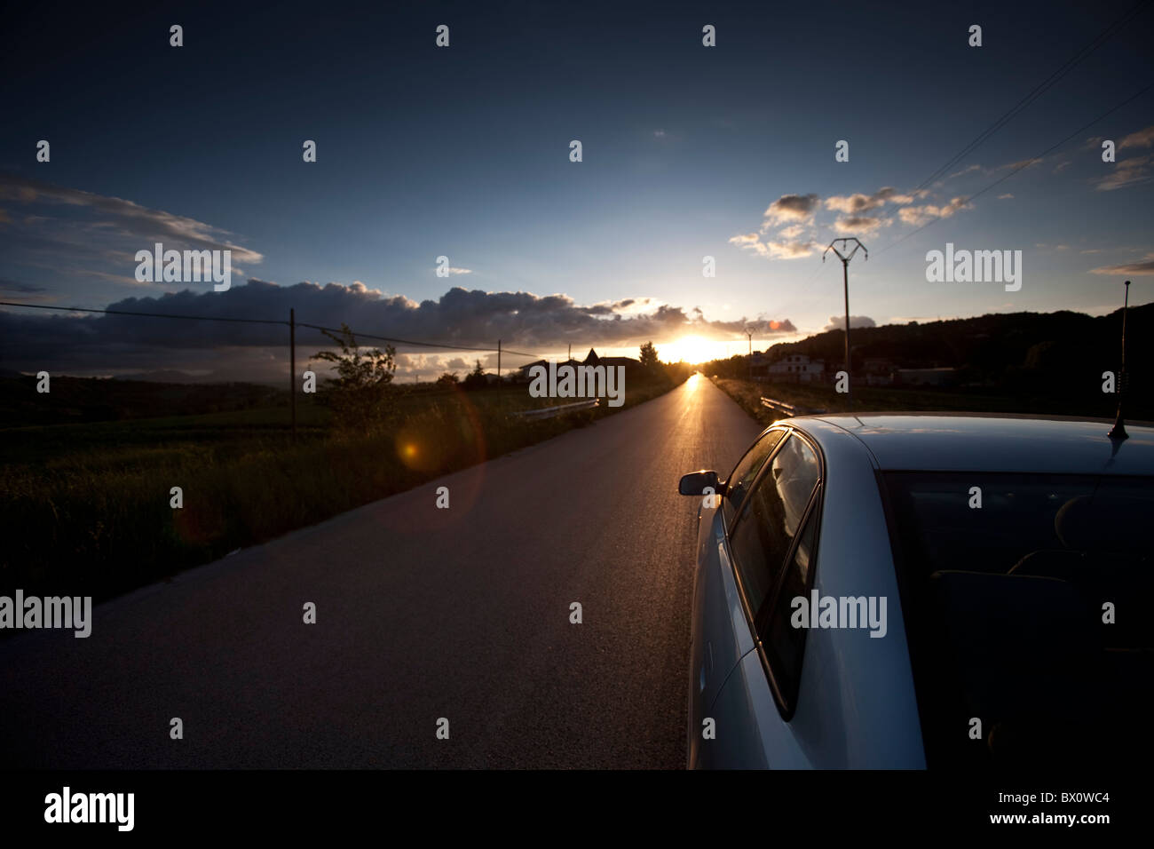car on the road in sunset Stock Photo