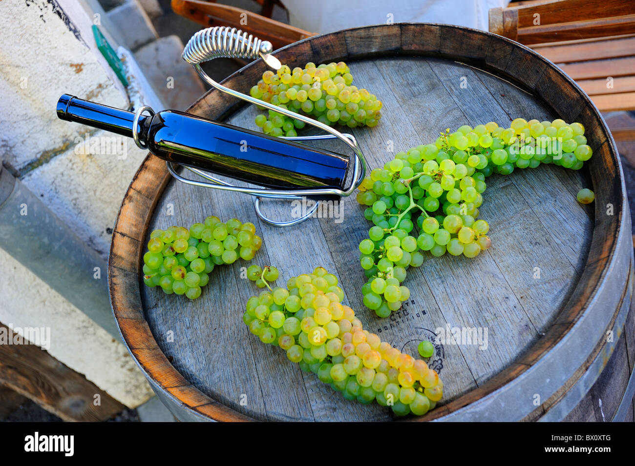 Wine bottle and grapes, on a winemaking barrel Stock Photo Alamy
