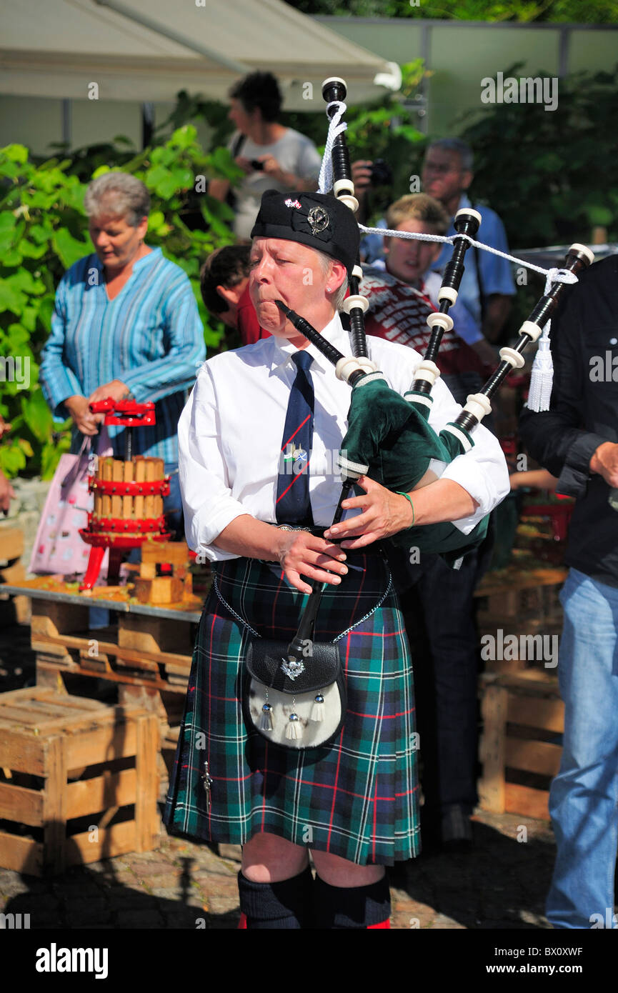 A woman plays the bagpipes at a Swiss wine festival. Stock Photo