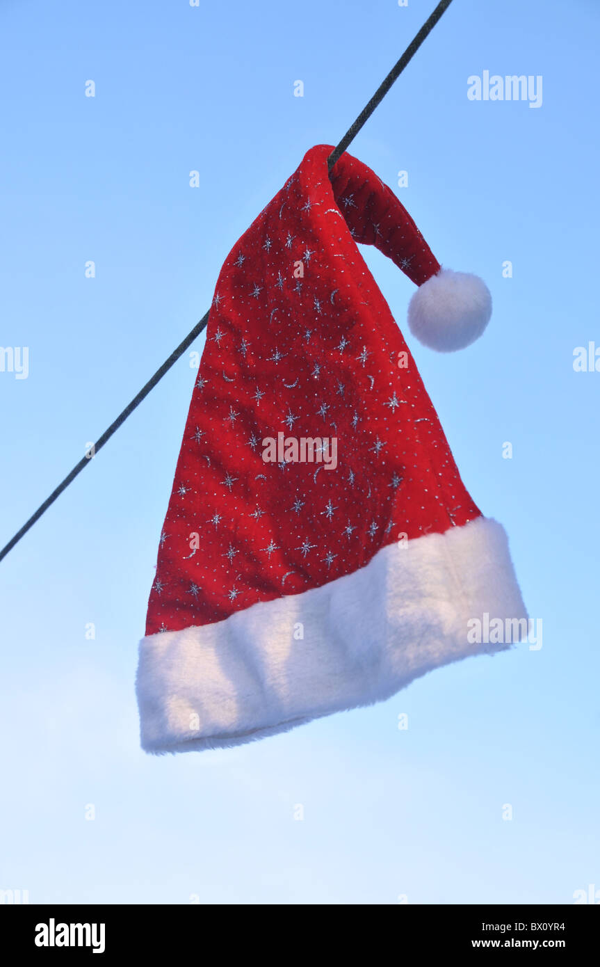 a Santa Claus hat hanging on a washing line. Stock Photo