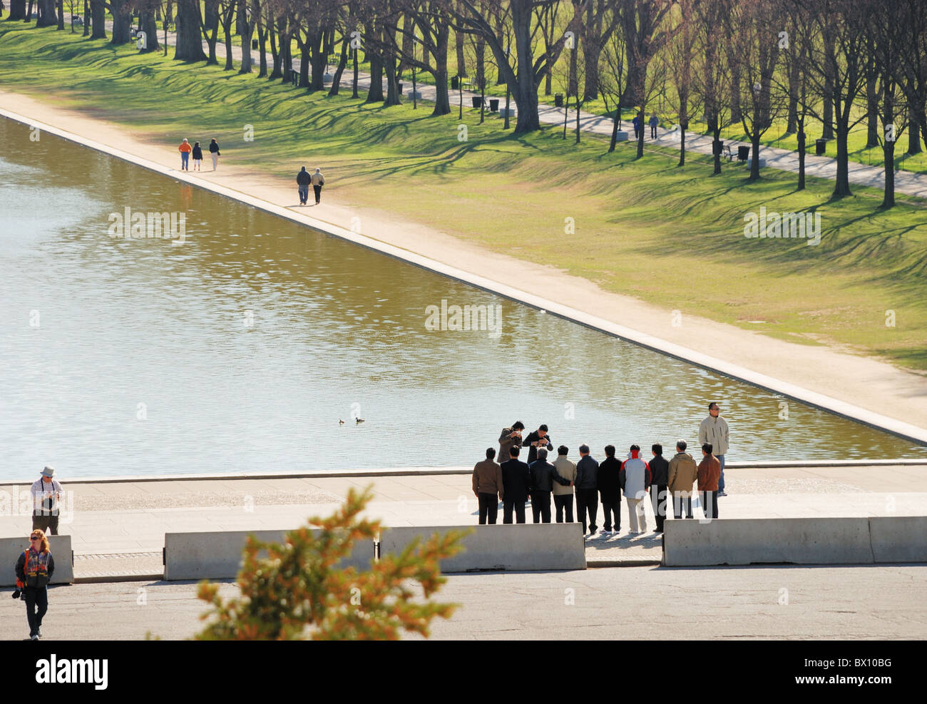 Wading Pool in front of Lincoln Memorial, Washington, DC. Asian tourists stand in a line for photos from fellow travelers. Stock Photo