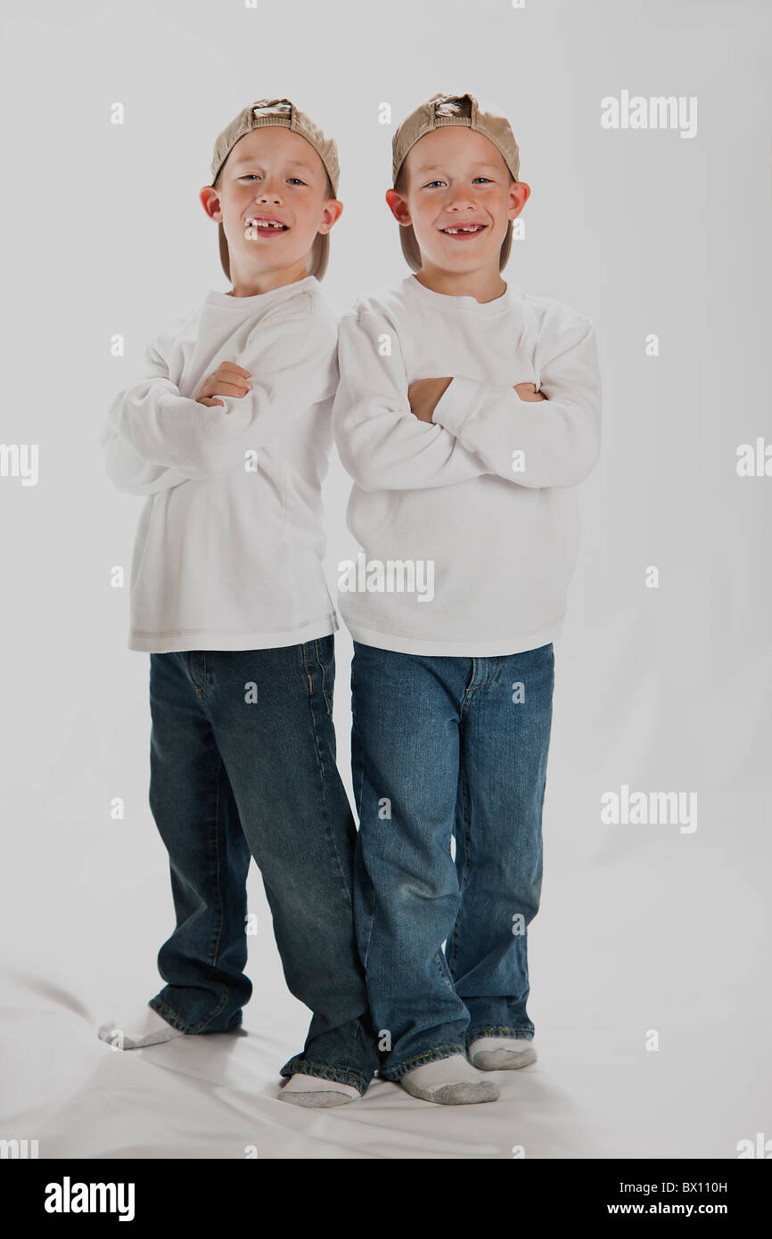 6 Years old boys identical twins wearing a baseball hats Stock