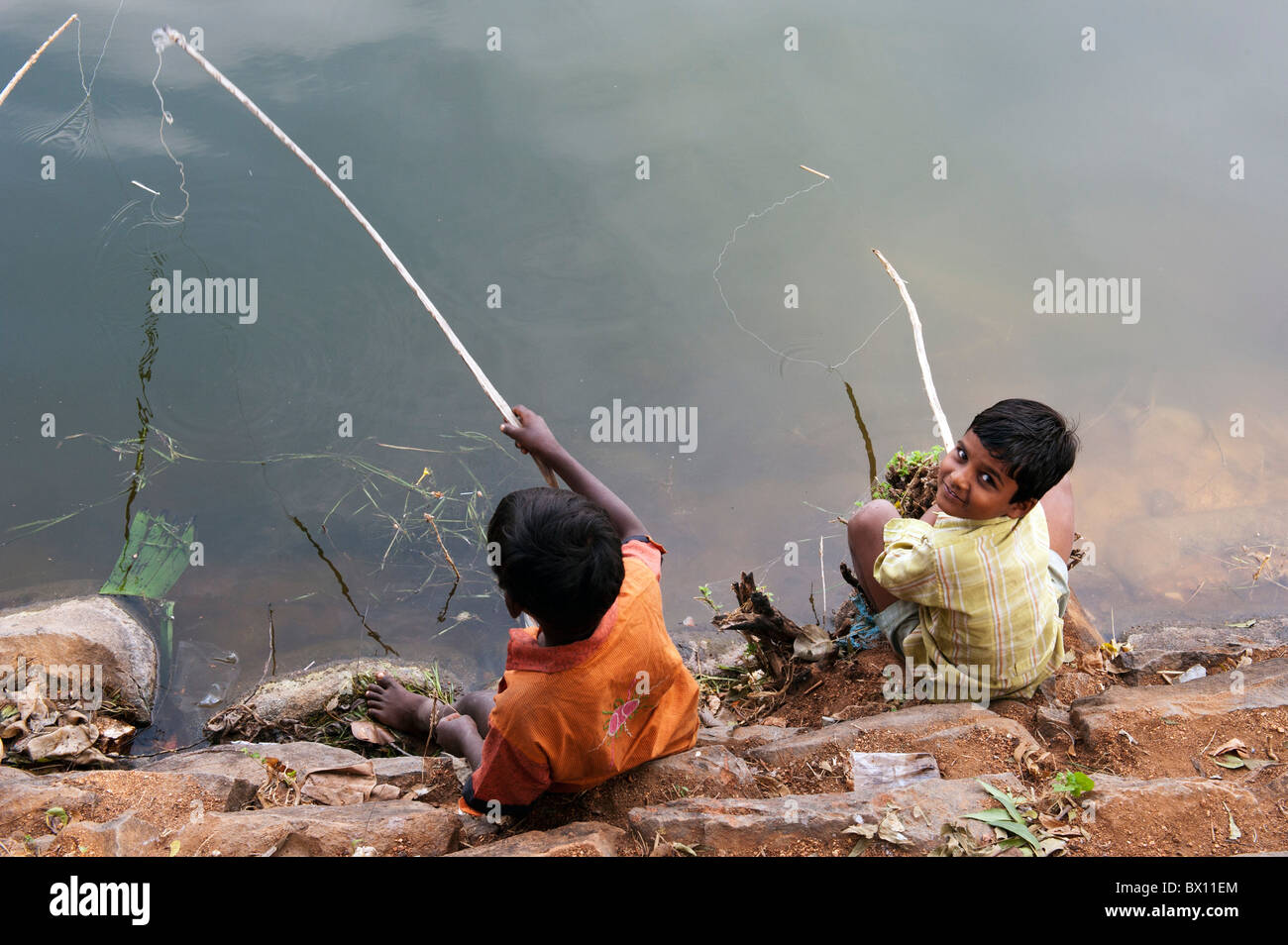 Indian boys fishing with homemade rods in a lake, Kothacheruvu, Andhra