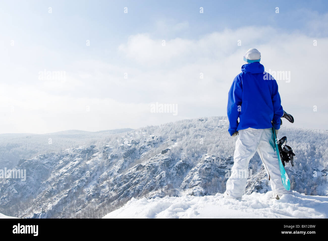 Rear view of sportsman with snowboard standing on top of mount Stock ...