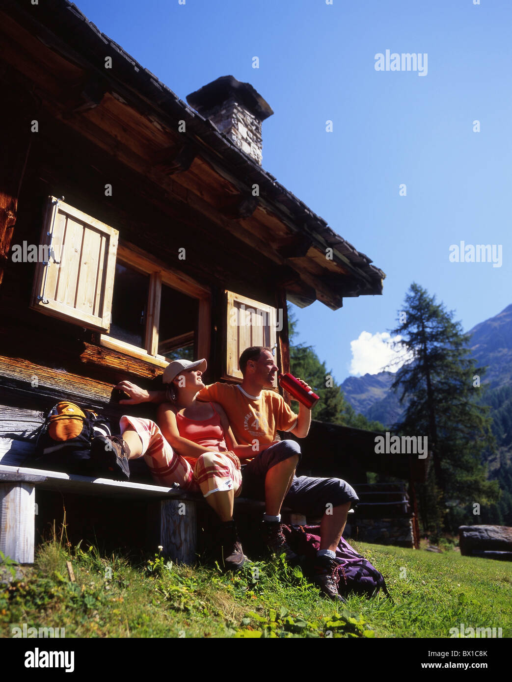 Hiking hiker couple relax rest picnic chalet hut house home mountains Alps alpine cabin Vinschgau Italy Stock Photo
