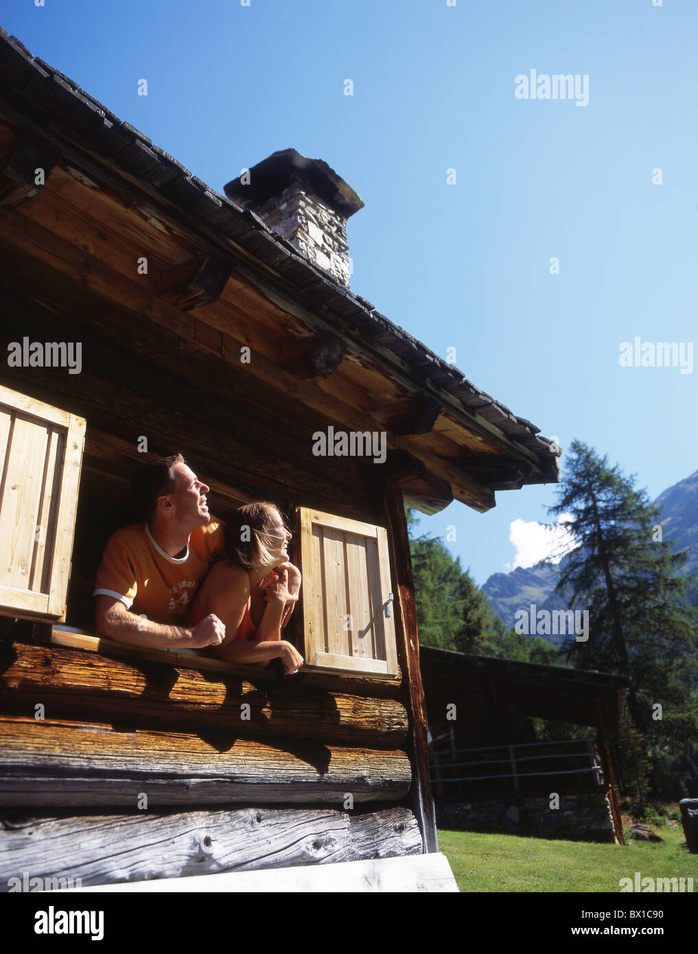 Couple alpine cabin hut chalet window holidays vacation mountains Alps spending night rents summer cottage Stock Photo