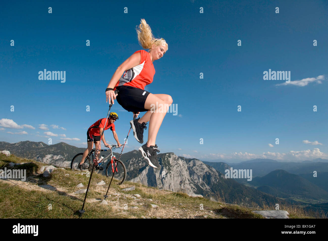 Mountain bike Biking man bicycle bike bike woman Nordic Walking action jump hiker hiking mountains Alps Stock Photo