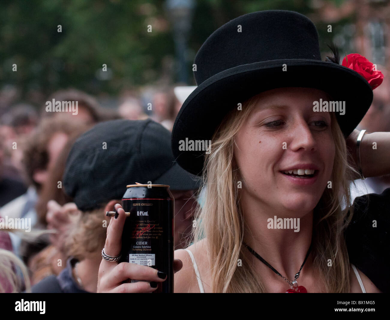 Happy woman in a crowd wearing a top-hat Stock Photo