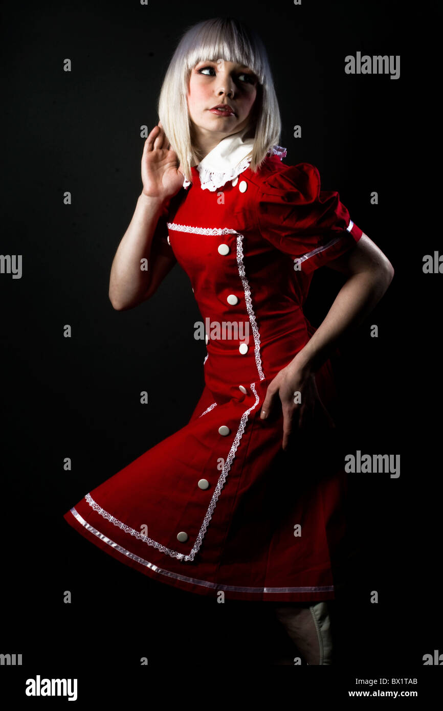 Fashion portrait of a young blonde model wearing a red gothic lolita dress. Stock Photo