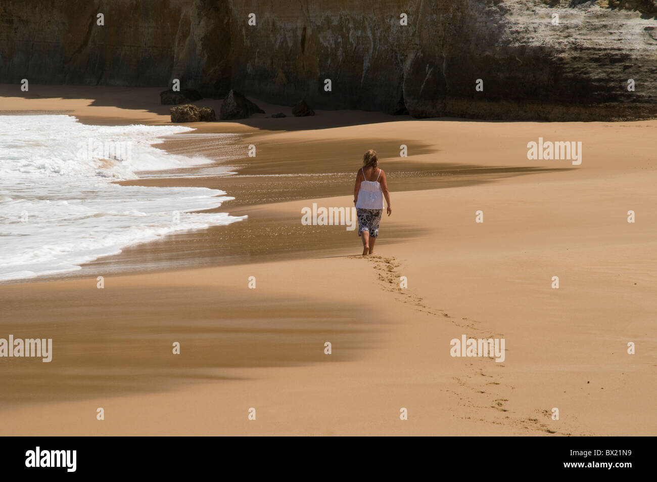 Woman walking barefoot across the sand on an empty beach, Great Ocean Road,  Victoria, Australia Stock Photo - Alamy