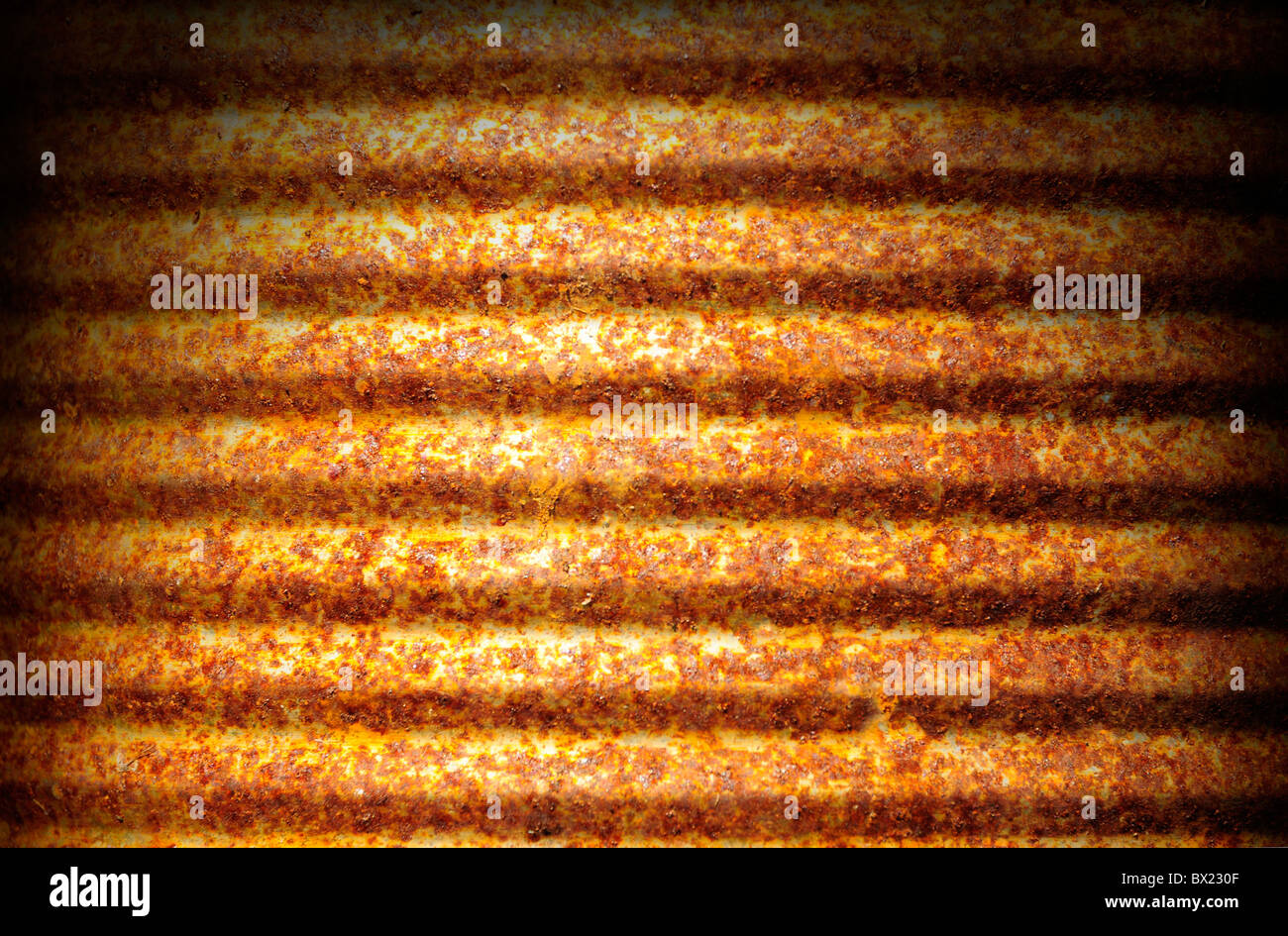 Rusty corrugated metal can surface lit dramatically from above Stock Photo
