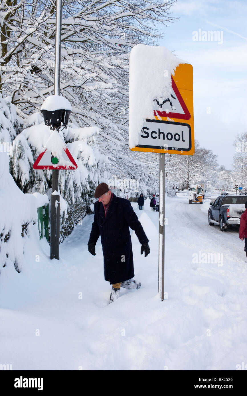 School Children's crossing warning sign in deep heavy snow Stock Photo