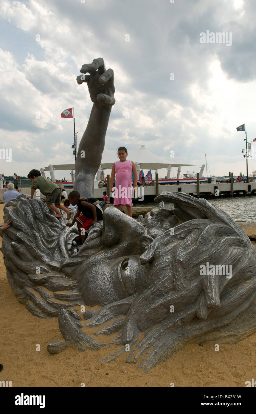 A child stands on top of the Awakening sculpture. Stock Photo