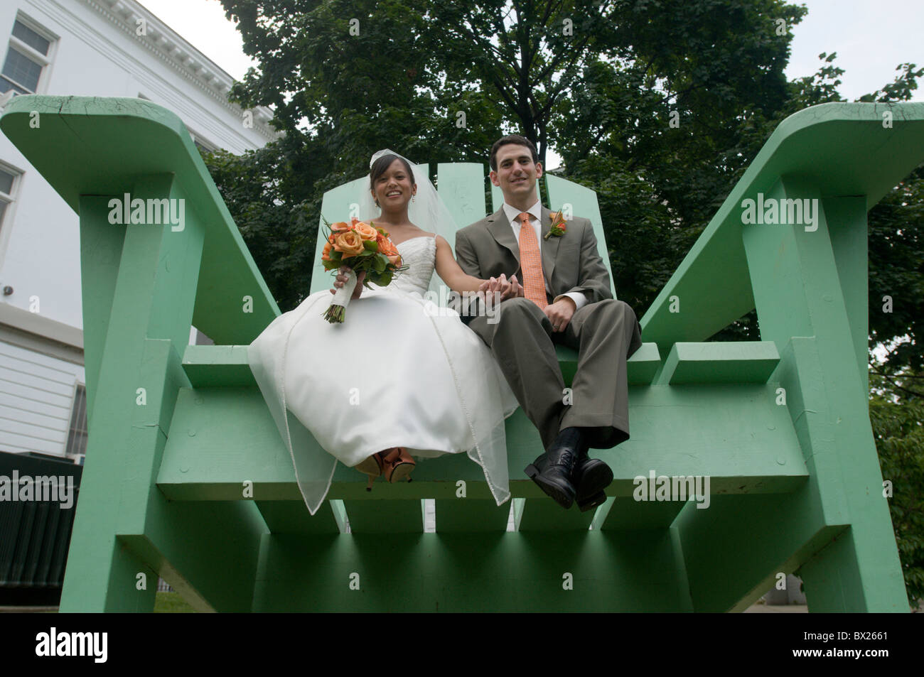 A recently married couple sit in a huge chair at the Duke Ellington High School for the Performing Arts. Stock Photo