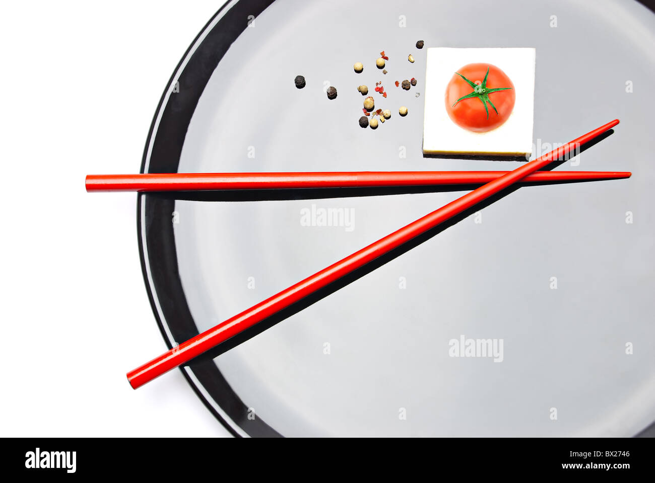 Asian Food Composition. Chopsticks, cherry tomato and white tofu cheese on plate Stock Photo