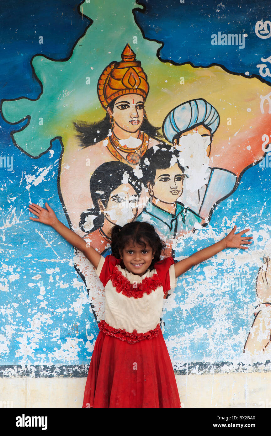 Indian girl standing in front of a colourful map of india painting on an indian building, Andhra Pradesh, India Stock Photo