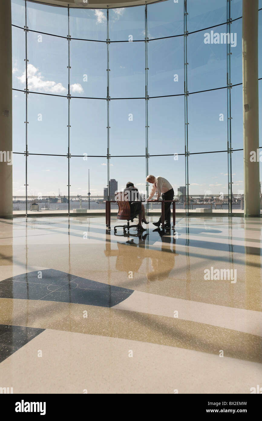 Business people working in large office with glass wall Stock Photo