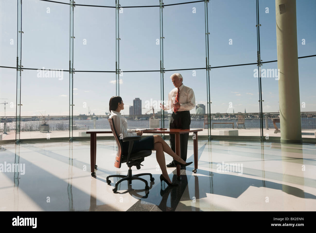 Business people working in large office with glass wall Stock Photo - Alamy