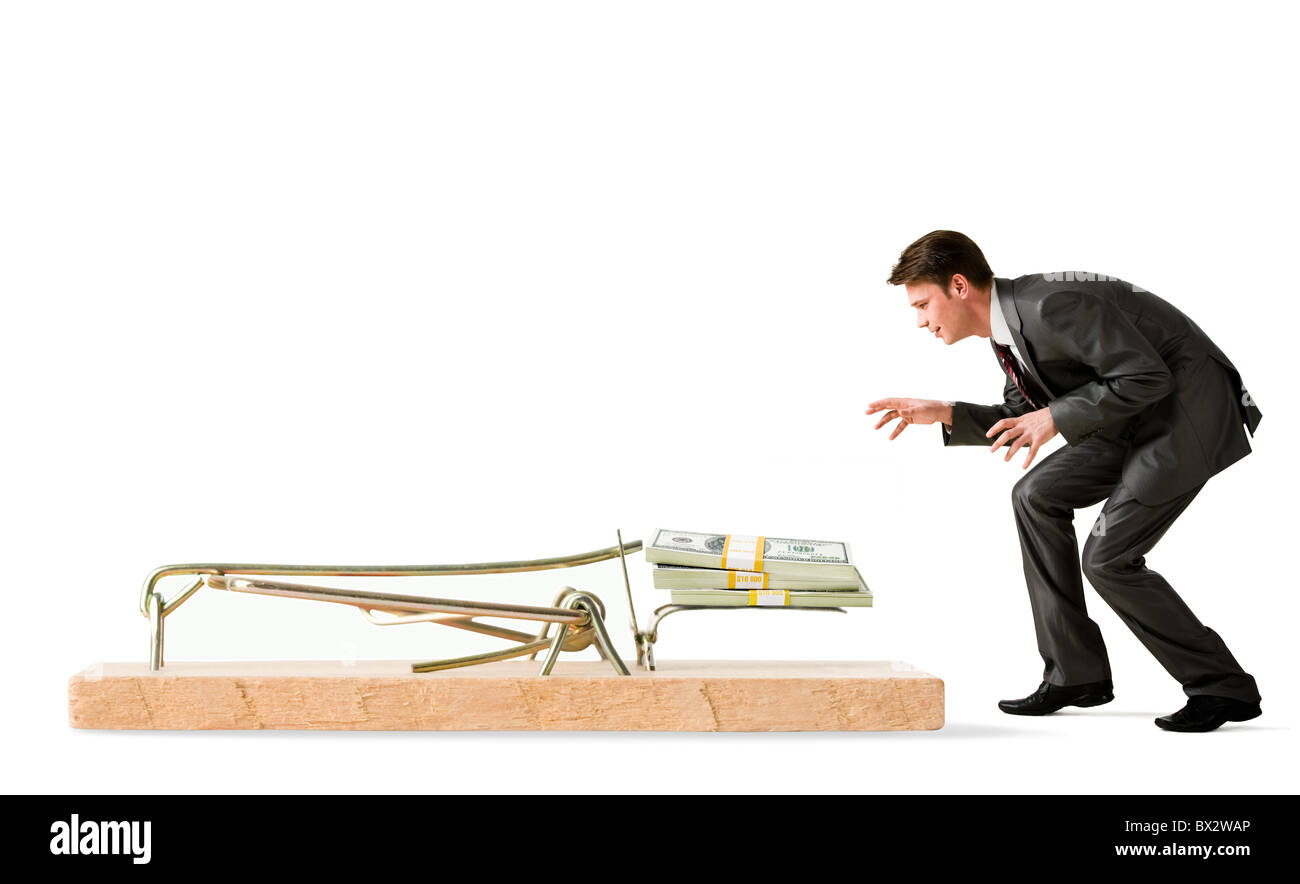 Photo of attentive businessman standing by mouse trap and looking at money Stock Photo