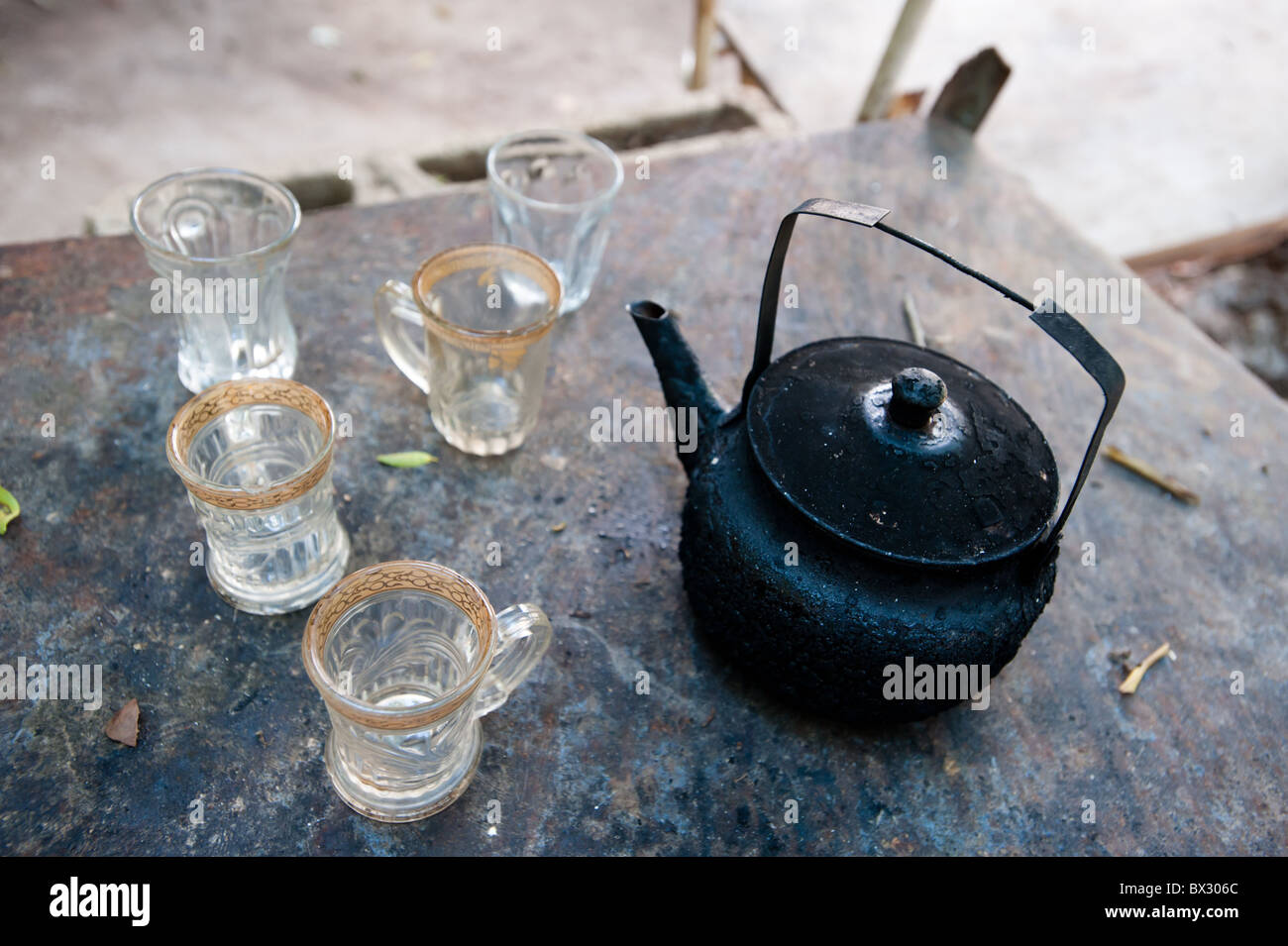A soot-blackened tea pot and empty tea cups. Stock Photo