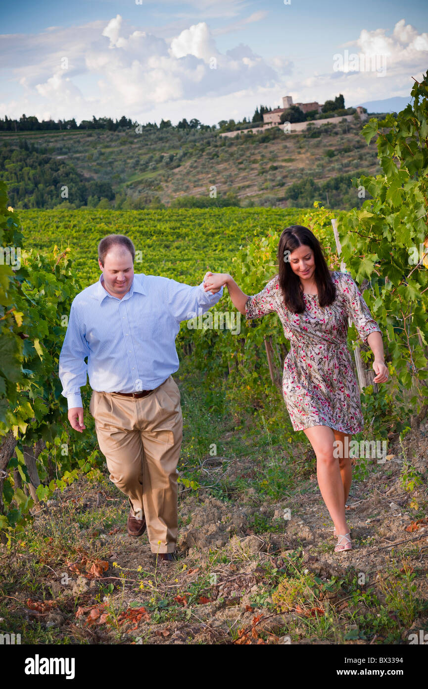 Couple walking hand in hand in a vineyard Tuscany Italy Stock Photo
