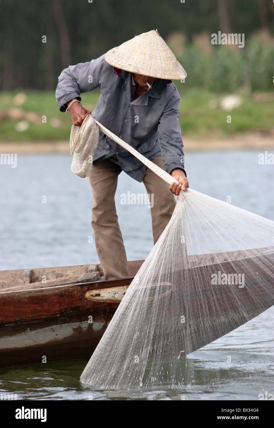 Fisherman throwing net from boat hi-res stock photography and