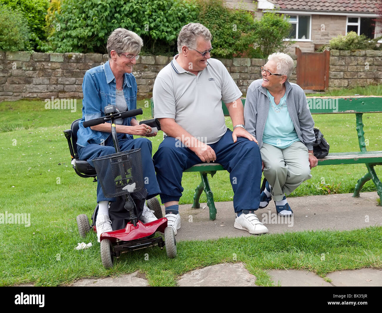 Friends in their 60's seated passing the time of day l to r:- Mrs Joan Morgan, Mr James Marshall and Mrs Doris Hall Stock Photo