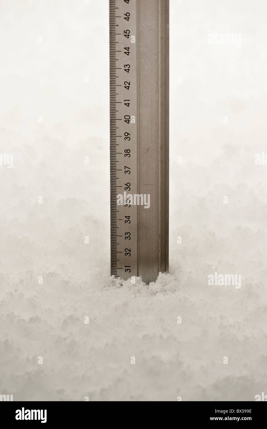Metric metal ruler measuring the depth of snow - 30cm 300mm Stock Photo