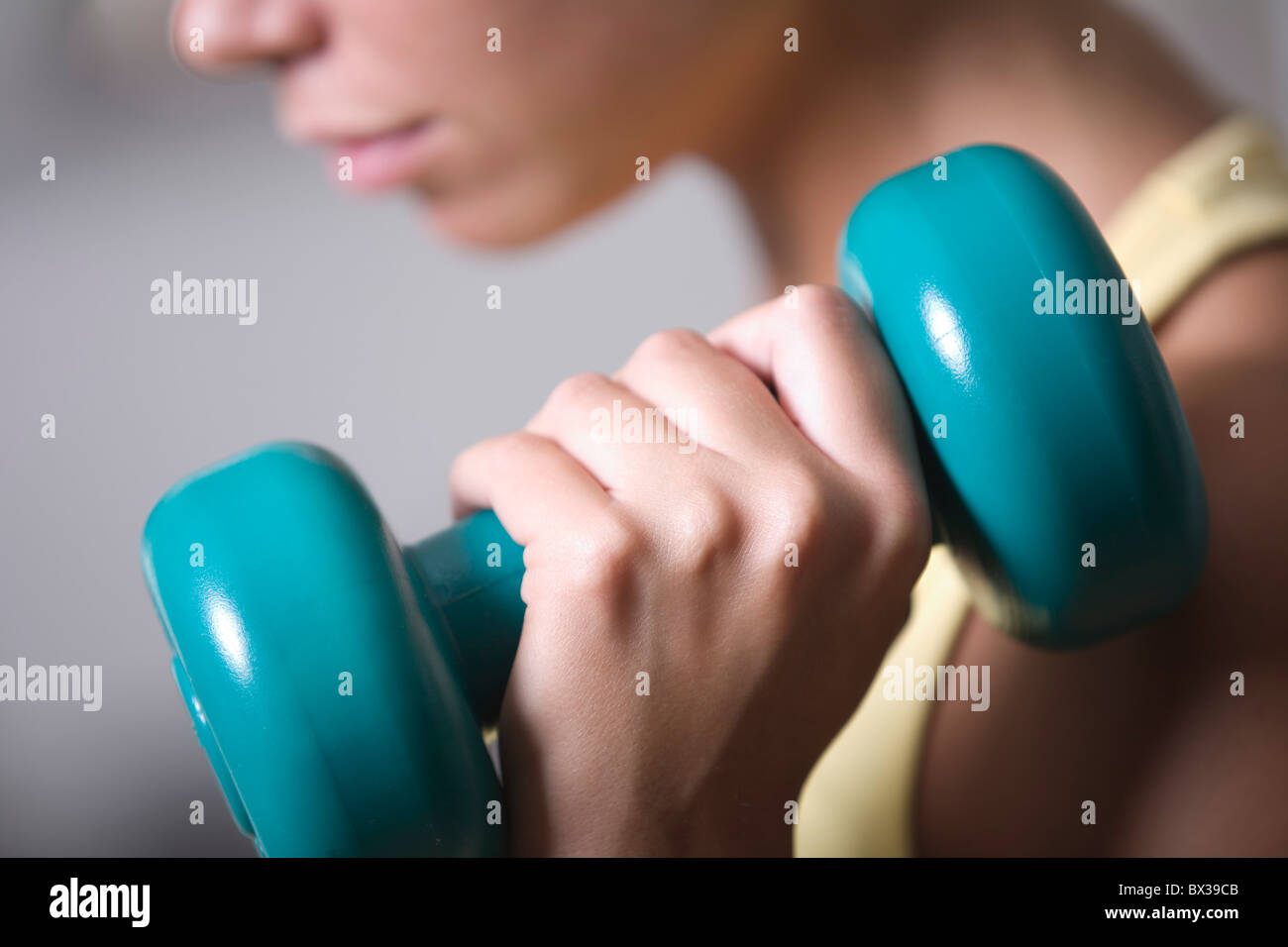 close-up of young woman exercising with dumb bell Stock Photo