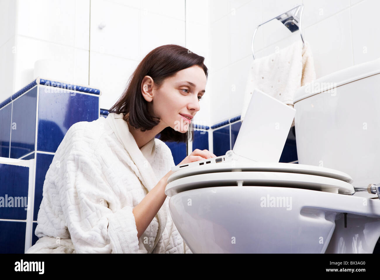 young woman with laptop computer in bathroom Stock Photo Alamy
