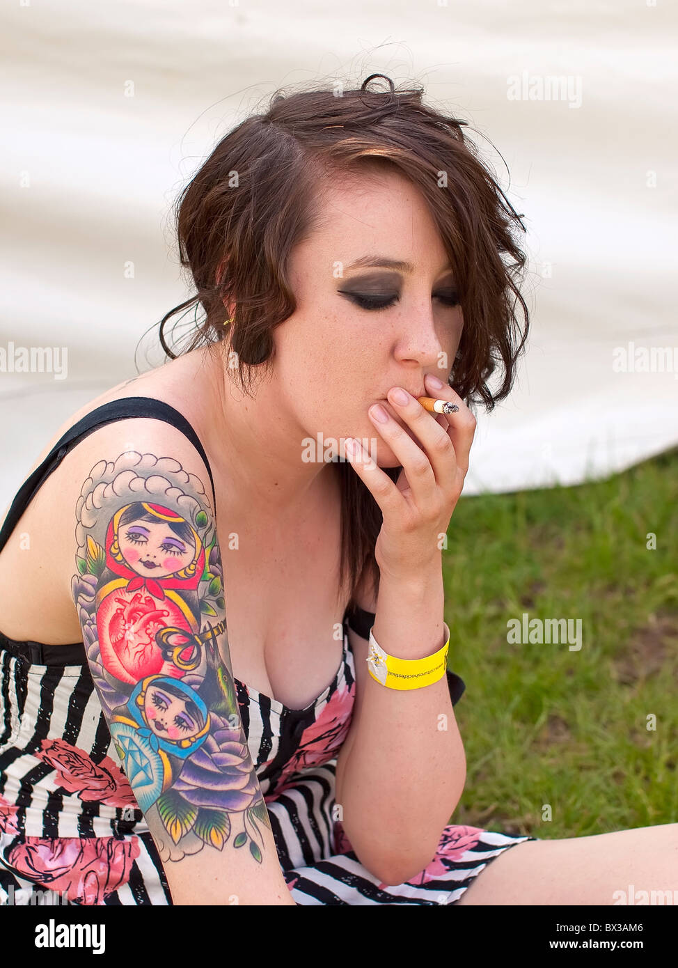 Lucy a trendy young female adult nineteen year old with tattoos drawing on a cigarette Stock Photo