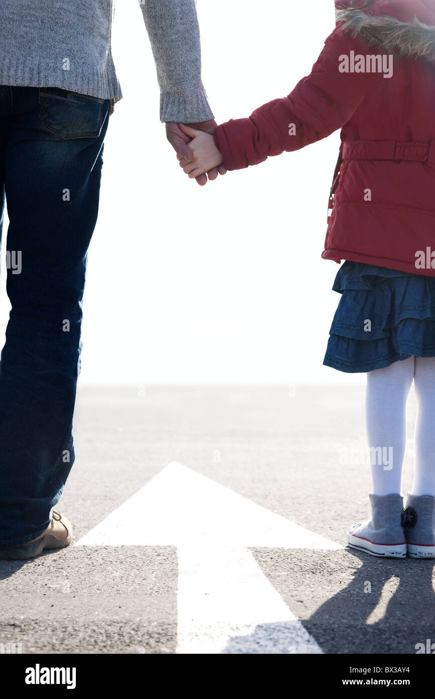 rear view of father taking young daughter by the hand Stock Photo