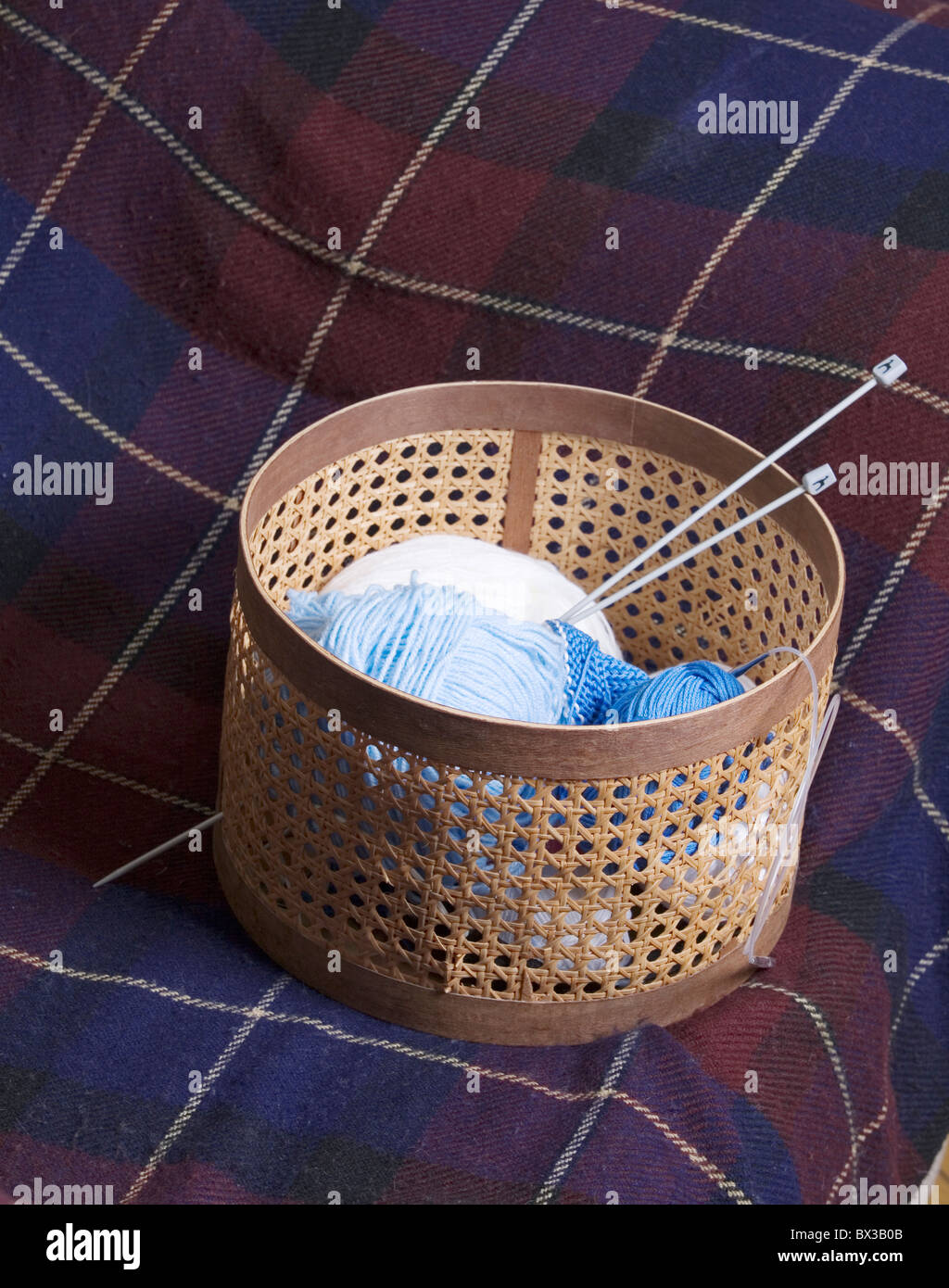 still life of wool and knitting needles in basket Stock Photo