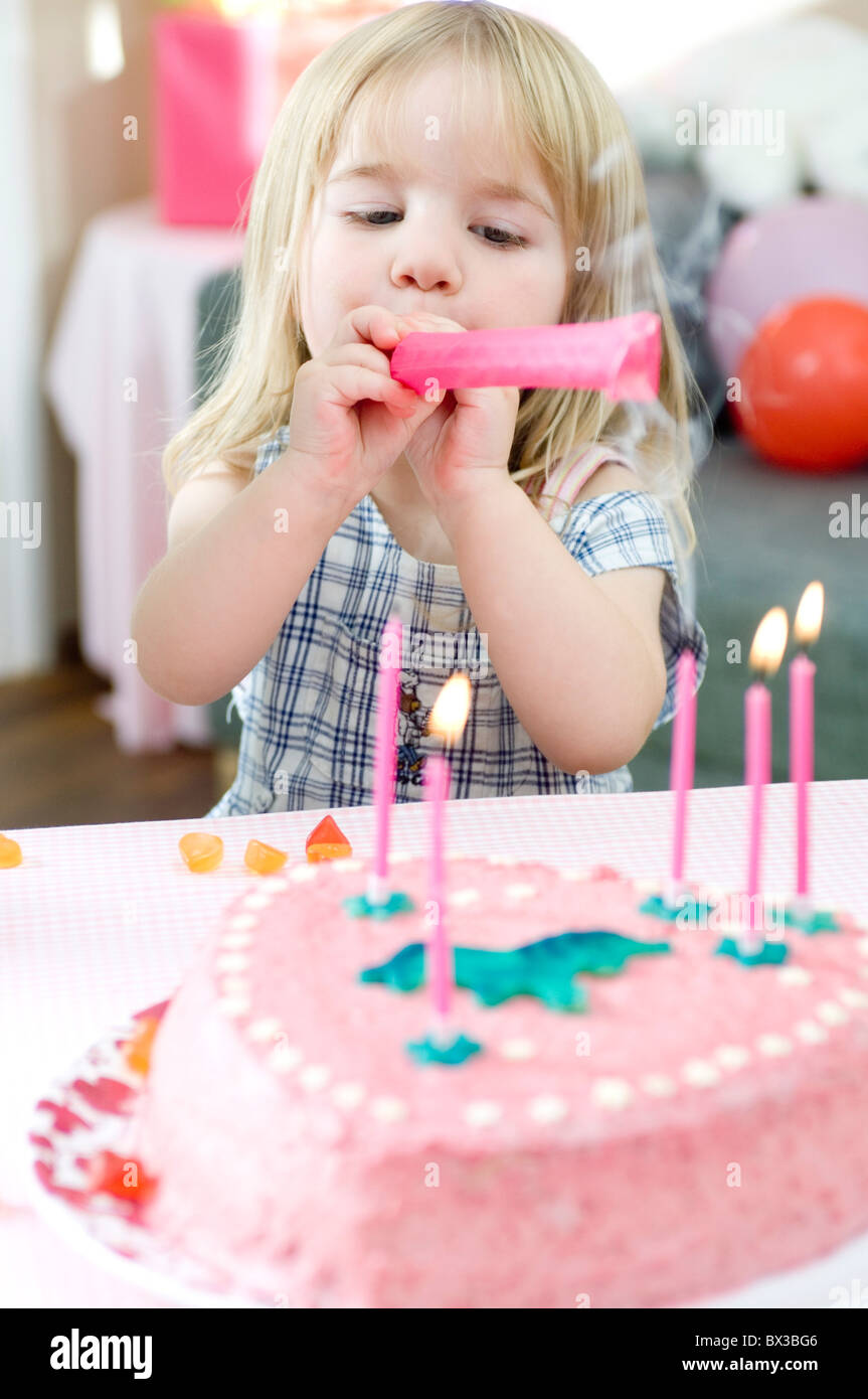 Portrait Of Young Girl Blowing Out Candles On Birthday Cake Stock Photo portrait-of-young-girl-blowing-out-candles-on-birthday-cake-stock-photo