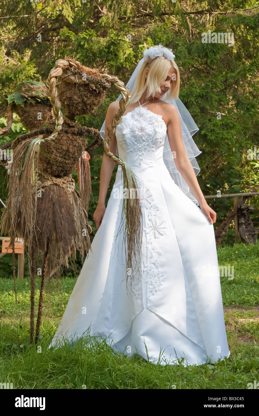 Beautiful blonde bride in white dress posing outdoor Stock Photo - Alamy