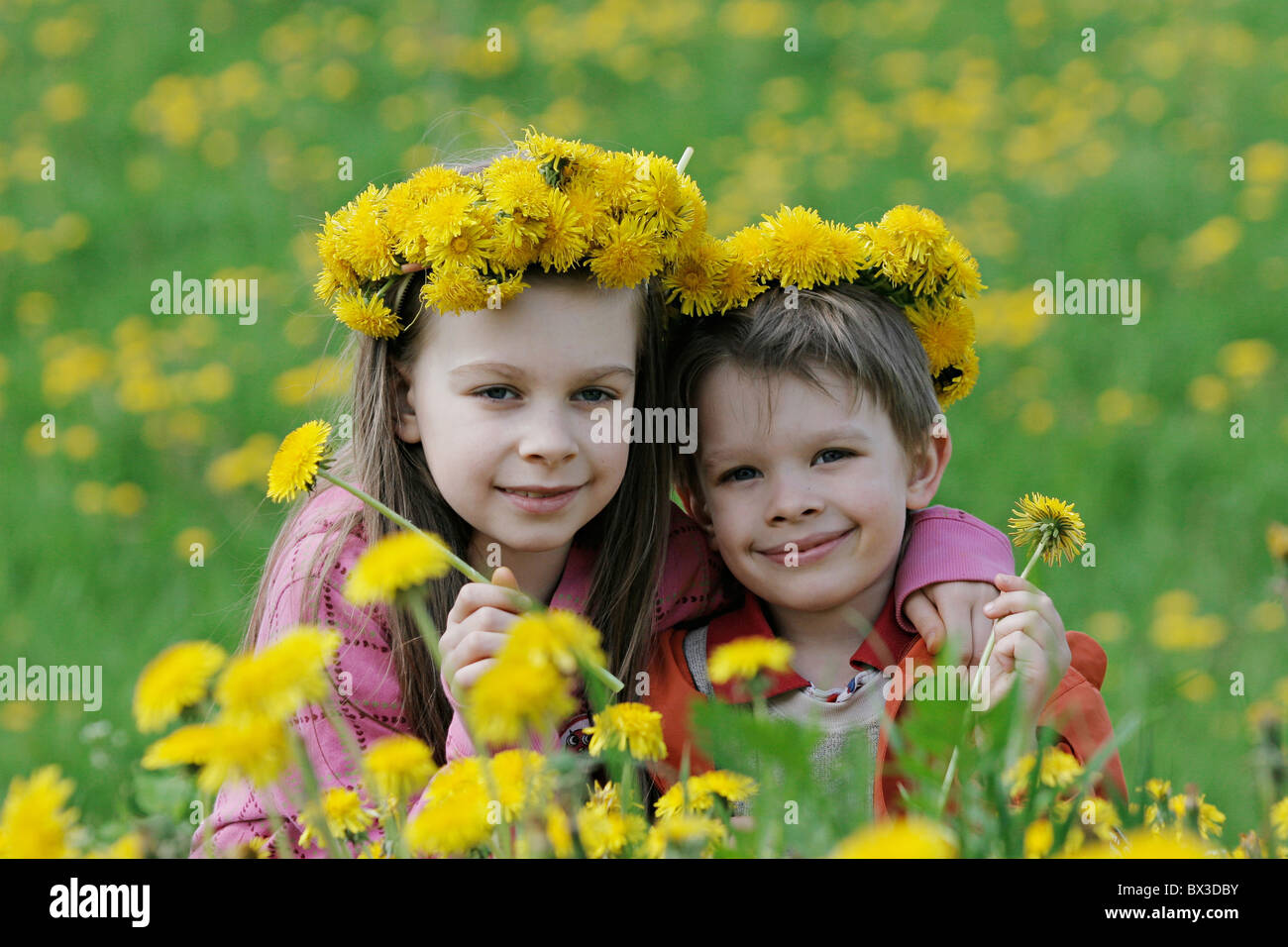 Brother and sister enjoy summer time in the dandelion meadow Stock ...