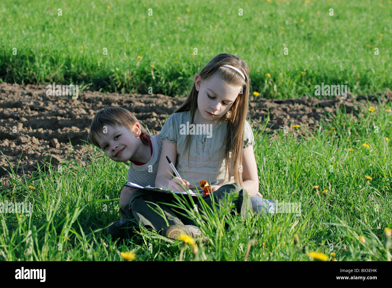 Brother and sister enjoy summer time in the green grass Stock Photo - Alamy