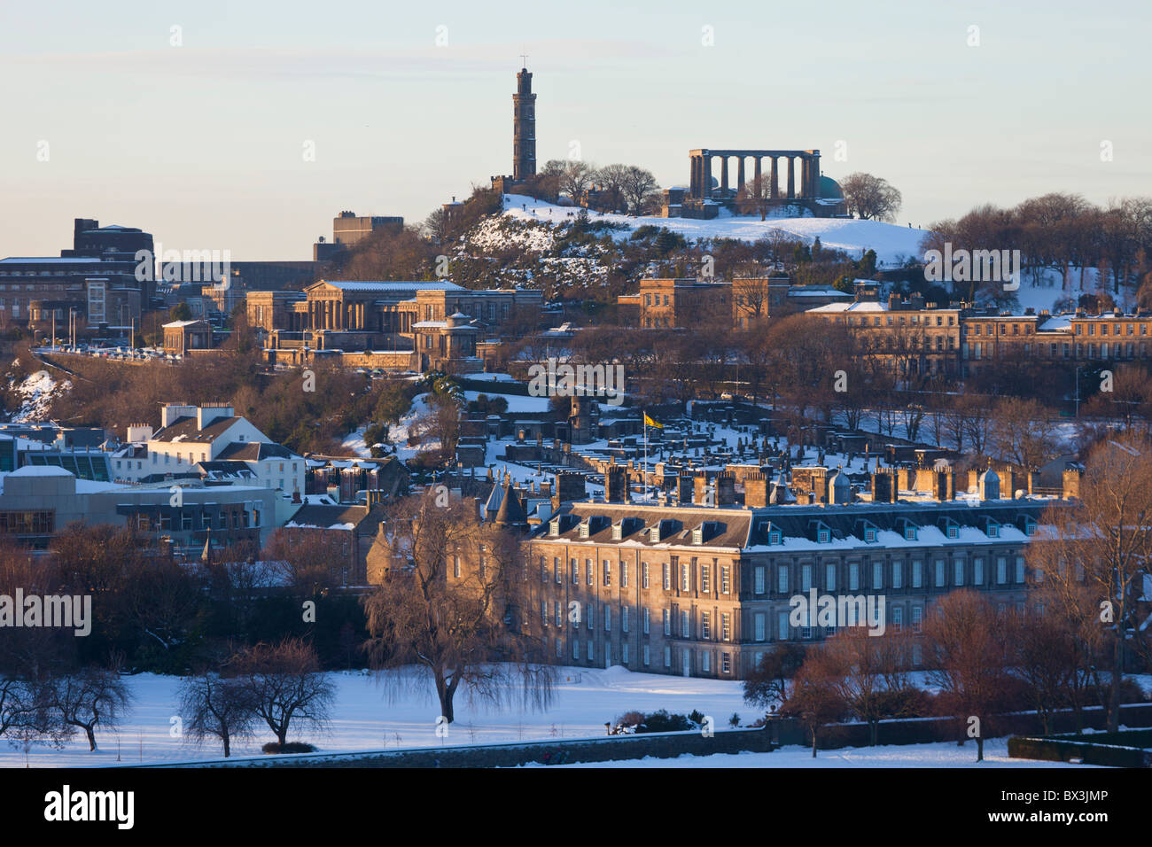 Snowy Holyrood Park, Edinburgh, with Holyrood Palace and Calton Hill at sunset. Stock Photo